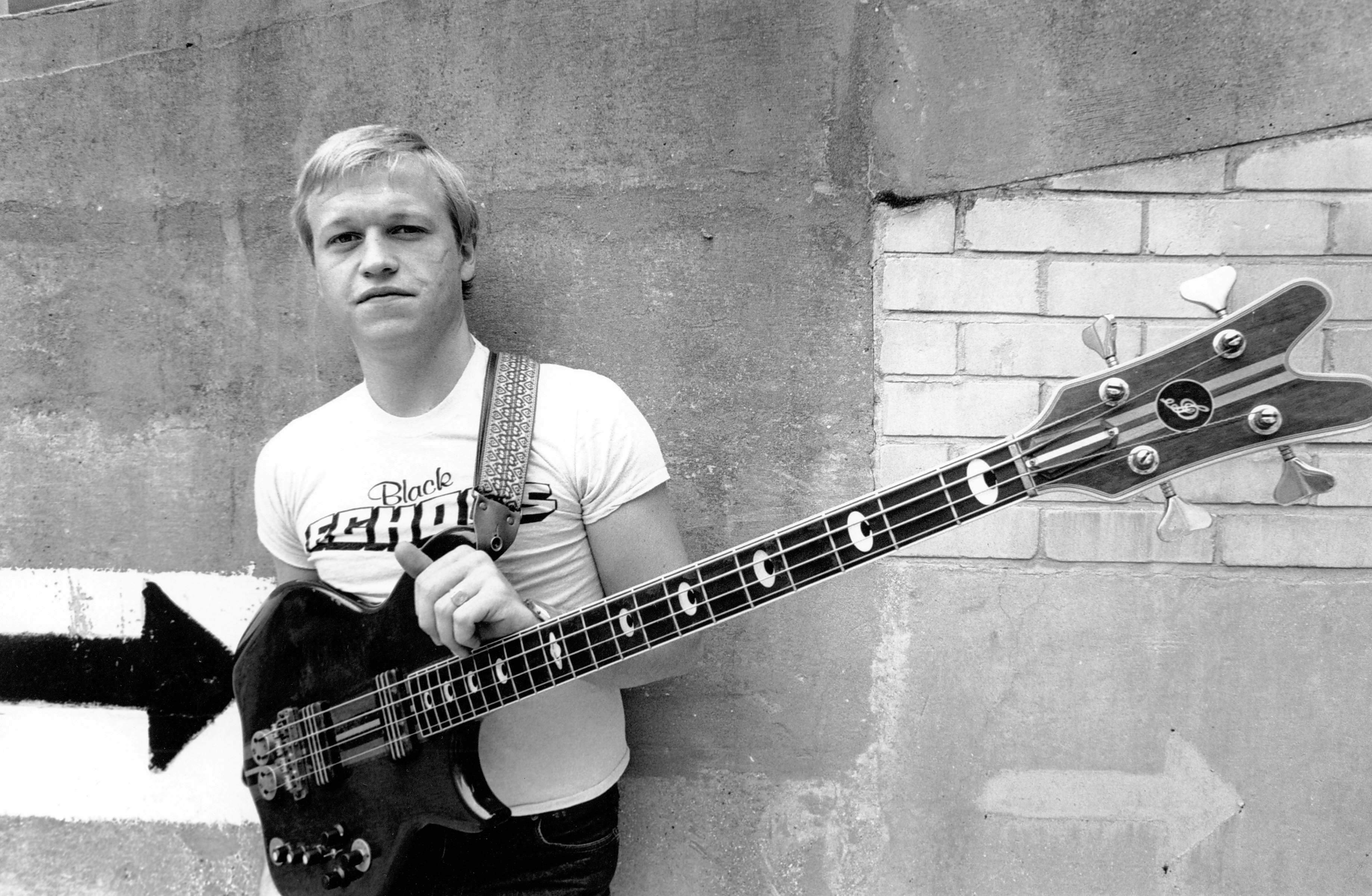 Singer, songwriter, and bassist Mark King of Level 42 with <i>Black Echoes</i> T-shirt, 1980. Photo by David Corio via Michael Ochs Archives/Getty Images.